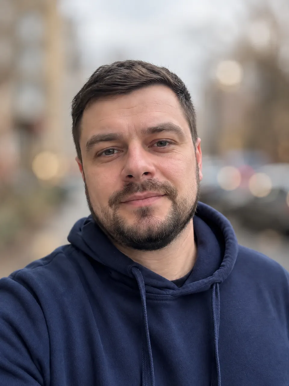 Размытие фона нейросетью: мужчина резкий, дома и машины на фоне превратились в мягкое боке